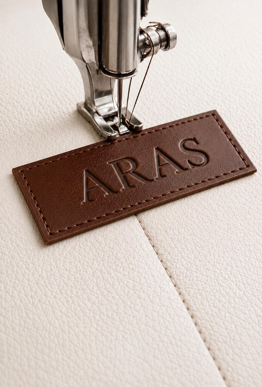Interior ARAS patch being stitched onto cream leather